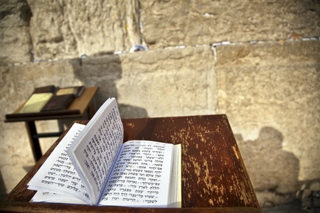The biblical Book of Psalms opened on one of the pages of the morning prayer, resting on a pedistal . There's also a shadow of a Jewish orthodox man on the wailing wall in the background.
Shot in the western wall in the old city of Jerusalem.の写真素材
