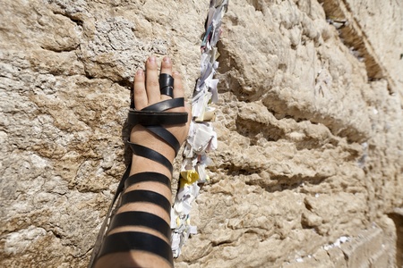 The left hand of a Jewish adult (early 30's) Caucasian man wrapped with Phylacteries, resting on the holy Western Wall (aka Wailing Wall) in the old city of Jerusalem, Israel.の写真素材