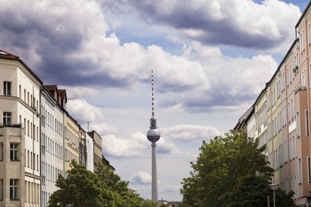 View of the blocks of buildings that stretch along Strelitzer strasse and the Berlin Television Tower  Fernsehturm  in the distance, beneath blue cloudy sky のeditorial素材