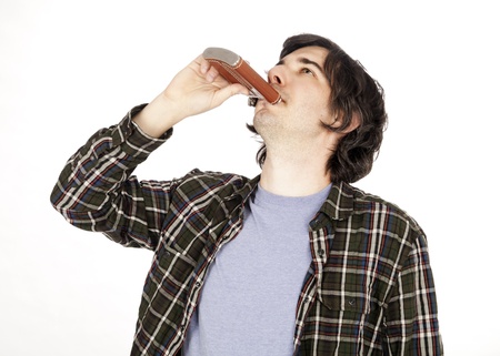 A caucasian male in his early 30's dressed in a casual attire, tilting his head up and drinking from...