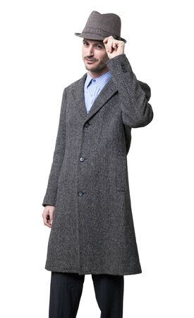 An adult male wearing an overcoat and raising his hat a little above his head, in a greeting gesture.
Isolated on white background.の写真素材