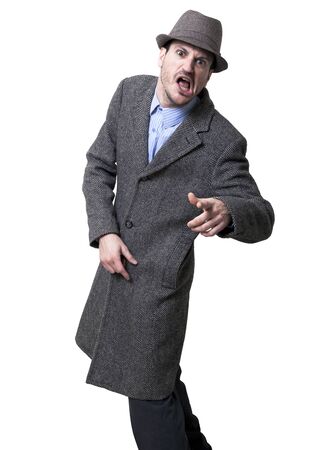 A young adult dressed in a gray overcoat and a gray hat, frozen in the middle of turning towards the camera with a furious expression on his face, as if in the middle of shouting.
Isolated on white background.の写真素材