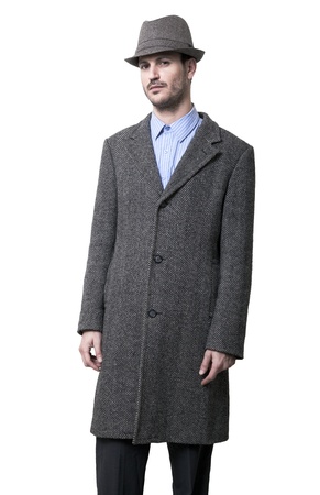 A young adult dressed in a gray overcoat and a gray hat with a slight confident smile on his face.
Isolated on white background.
の写真素材
