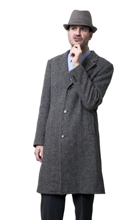 A person dressed in a gray overcoat and a gray hat  He seems to be buffeled, wearing a puzzeled facial experssion, and in general not looking very smart Isolated on white background の写真素材