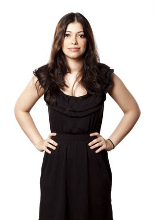 Beautiful young adult Caucasian woman in her mid 20's looking at the camera with a smile on her face and hands on her hips. Isolated on white background.の写真素材