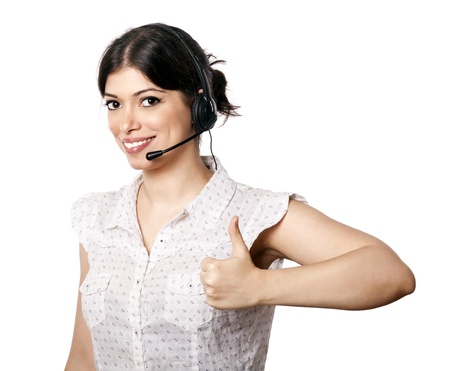 A bautiful young adult Caucasian woman wearing a headset and giving the camera a lovely smile along with a thumbs up  Isolated on white background の写真素材