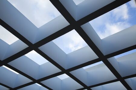 Low angle shot of a patio pergola on the background of lovely clody sky.の写真素材