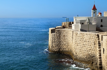 View at the surrounding wall of the old town of Acco (Acre) in Israel, bordering with the Mediterranean sea. The church on the right side is St. John Church.の写真素材