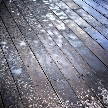 Wooden deck floor of a boardwalk, water sprayed by ricochets splashed off of waves breaking against the boardwalkの写真素材