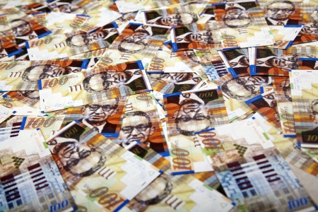 A high angle view of a very large amount of 100 NIS (New Israeli Shekel) money notes spreaded in a...