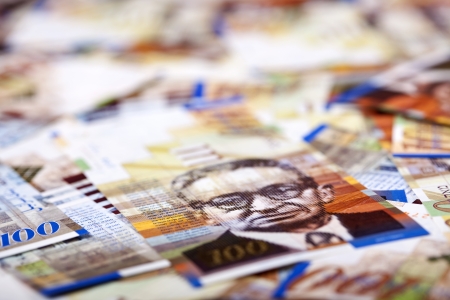 A high angle macro shot view of a very large amount of 100 NIS (New Israeli Shekel) money notes...