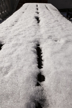 Closeup of snow on a picnic tableの写真素材