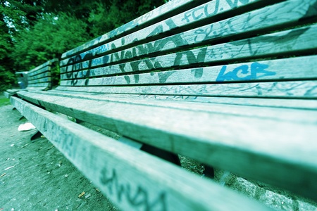 Wide angle view of a grafitti covered bench at Gorlitzer park, Berlin, Germany. Stylized with cross-process aesthetics.の写真素材