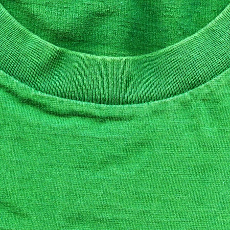 High resolution close up of bright green cotton fabric with part of a shirt's collar crossing.の写真素材