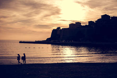 Silhouette of coastal city in beautiful sunset light,gorgeous city scape, panoramic landscape,summer travel.Seaside beach at night.Old city of Ulcinj, the southernmost city of the Montenegroの写真素材
