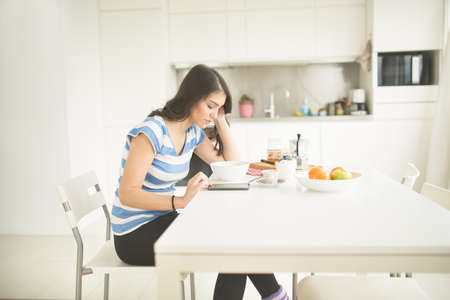 Modern working woman lifestyle-drinking moka coffee in the morning in the kitchen,starting your day.Positive energy and emotion.Productivity,happiness,enjoyment,determination.Morning ritualの写真素材