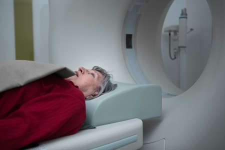 Old lady sleep on a CT Scan bed and panel control by Radiologic technician.Patient Prepare For...