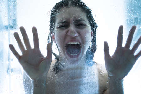 Kidnapped abused hostage victim woman in emotional stress and pain, afraid, restricted, trapped, call for help, struggle, terrified,locked.Victim , human trafficking,domestic violenceの写真素材