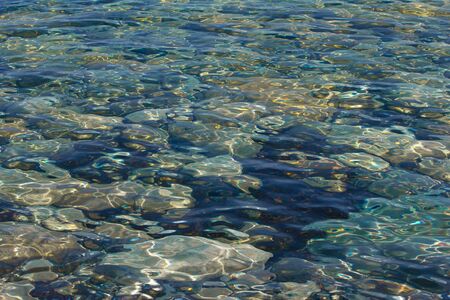 Texture of rocks under a clear blue and green water.の写真素材