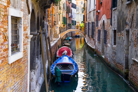 Small channel in Venice, Italy with boats parked around.の写真素材