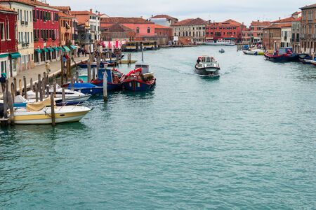 Murano canal full of boats parked around.の写真素材