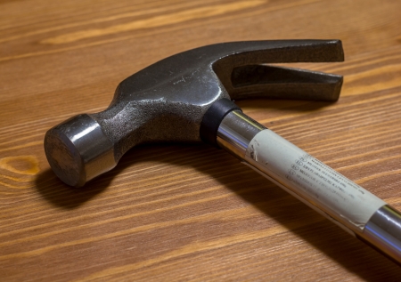 Steel hammer over a wooden table の写真素材