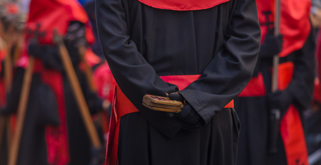Red nazareno with a wooden instrument in the Good Thursday during Holy Week in Valladolid の写真素材