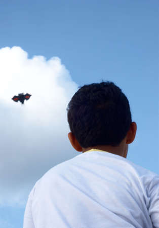 Playing with a paper kite in the skyの写真素材