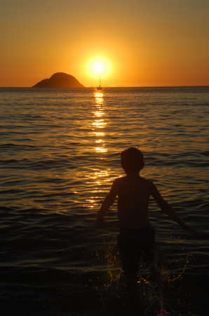 Kid playing on sunset on Itaipu Beachの写真素材