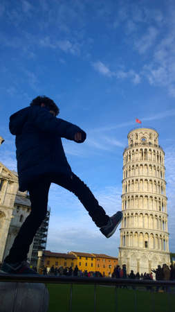 Kid kicking and fixing Pisa Towerの写真素材