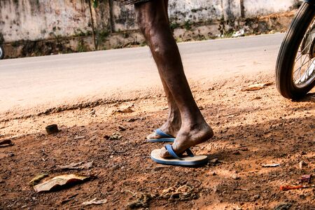 A man walking with clogs in India