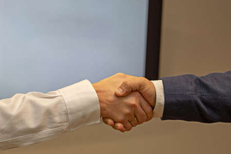 Close up of friendly handshake of business people. Business partners signing deal with handshake at...