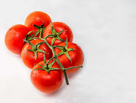 very fresh and healthy vine tomatoes with water drops on an isolated white background,healthy vegan food for a diet.Ketchup ingredient.の写真素材
