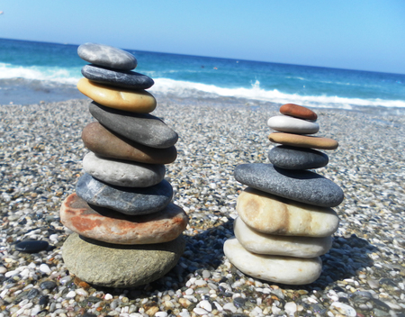 Pyramid of stones on the beach against the sea and sky.の写真素材