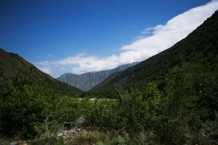 Midagrabindon waterfalls in the gorge. Mountains in the North Caucasus in summer. Mountain tops in...