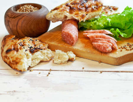 Slices of salami on wooden tableの写真素材