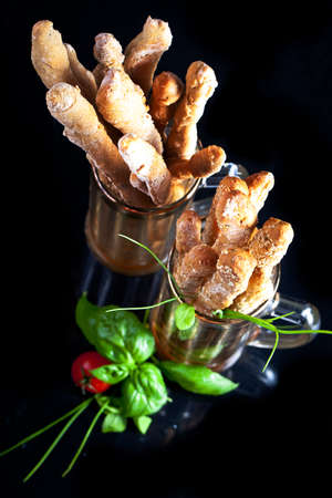 Grissini with prosciutto crudo and vegetables on black