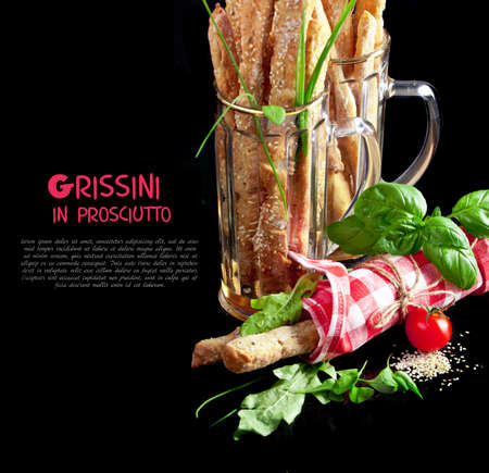 Grissini with prosciutto crudo and vegetables on blackの写真素材