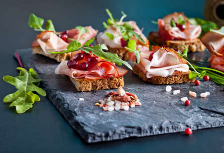 Sliced prosciutto with herbs and pomegranate seedsの写真素材