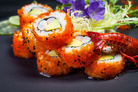 Sea crawfish and sushi on a slate dark plate with liquid smokeの写真素材