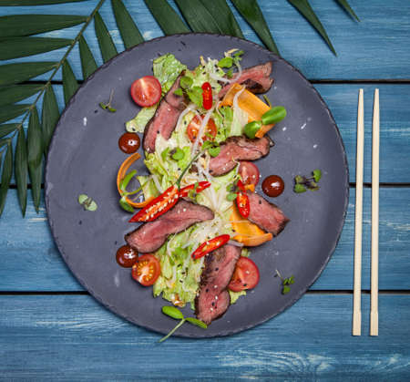 Japanese salad with meat, chili pepper, cherry tomatoes and fresh sproutsの写真素材