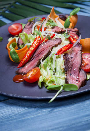 Japanese salad with meat, chili pepper, cherry tomatoes and fresh sproutsの写真素材