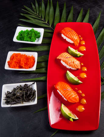 Sushi on red plate served with lime.の写真素材