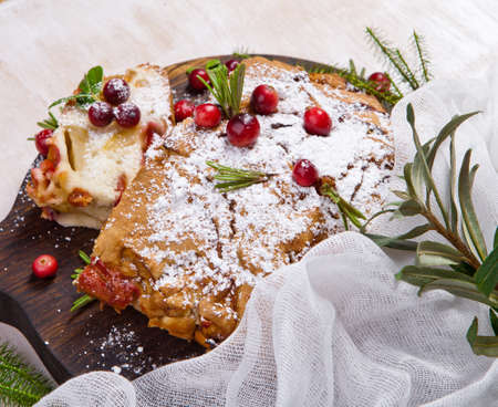 Delicious cranberry pie with fresh cranberries and herbs for Christmas on wooden plate.の写真素材