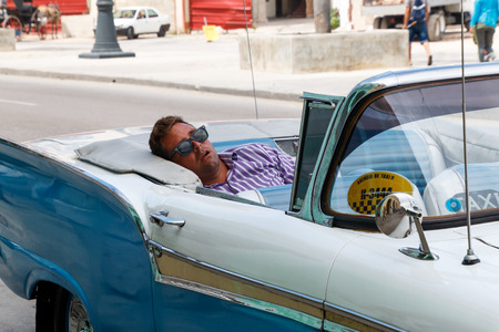 Havana, Cuba June 12, 2017. Taxi driver sleeping a nap before work