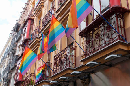Multicolored flags on a facade of a street in Madridの写真素材