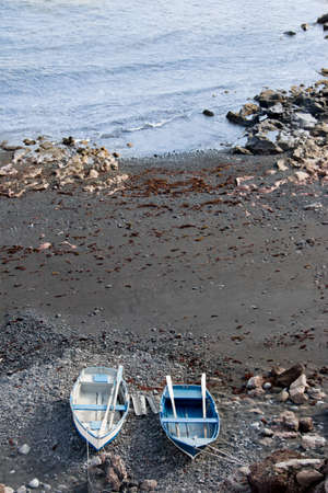 Rocky beach with fishing boats in lanzarote, canary islandsの写真素材