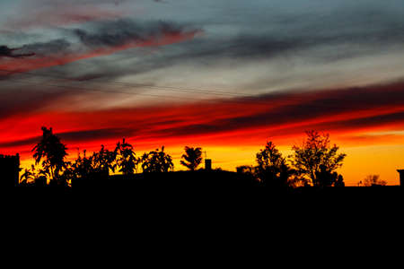 Photograph of a sunset with the sky colors extravagantly red and orangeの写真素材