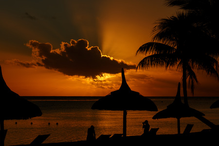 Sunset on the beach with silhouettes of a photographer and his modelの写真素材