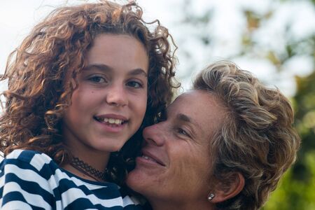 mother with her preteen girl in affectionate positionの写真素材